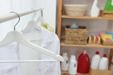 Rack with shirts in laundry room, space for text