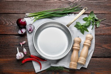 Flat lay composition with frying pan and fresh products on wooden table