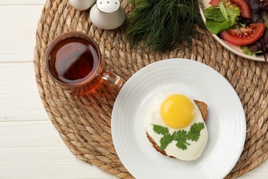 Delicious breakfast with fried egg served on white wooden table, flat lay