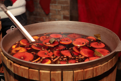 Photo of Large cauldron with tasty mulled wine at winter fair