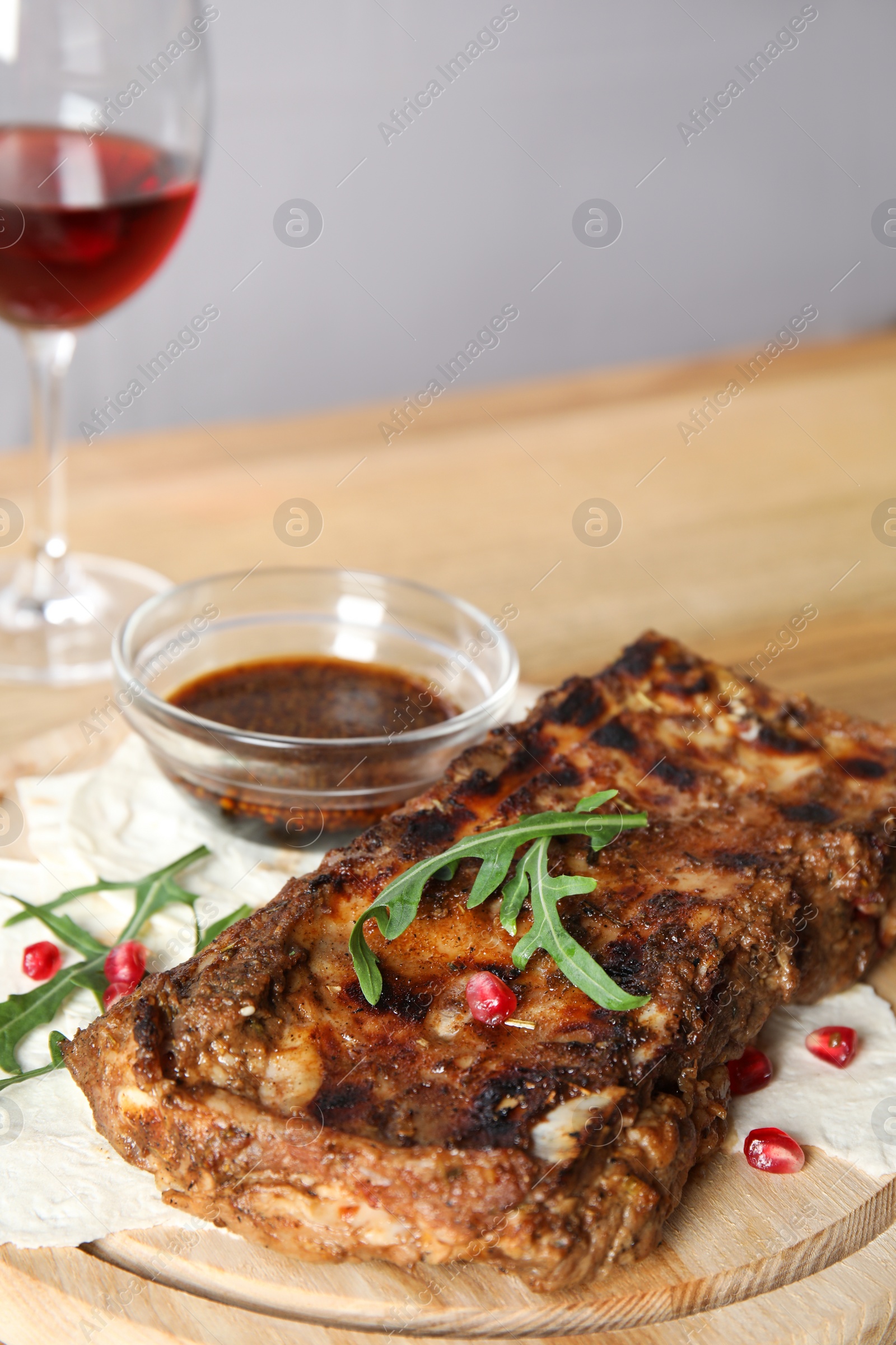 Photo of Delicious grilled ribs on wooden board, closeup. Space for text