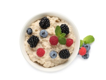 Photo of Tasty oatmeal porridge with blackberries, raspberries and blueberries in bowl on white background, top view