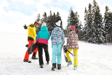 Group of friends with equipment in snowy mountains. Winter vacation