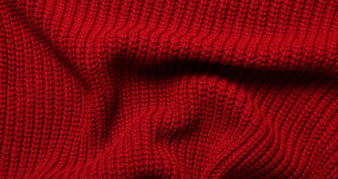 Photo of Texture of soft red knitted fabric as background, top view
