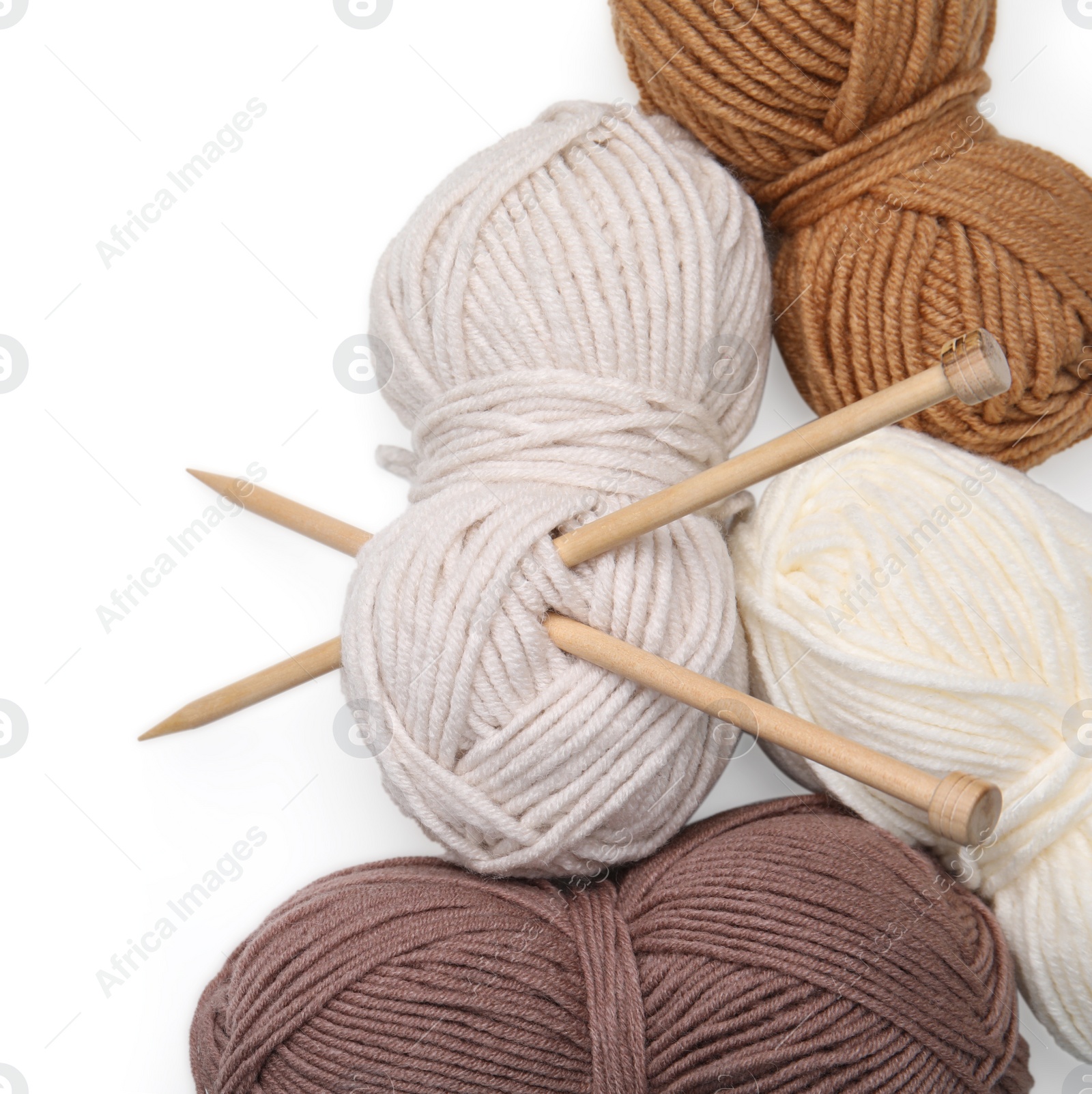 Photo of Soft woolen yarns and knitting needles on white background, top view