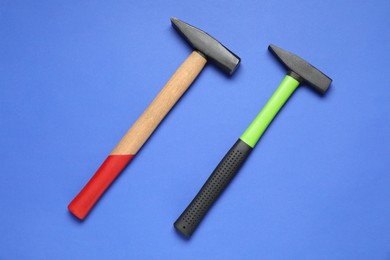 Photo of New hammers on blue background, top view