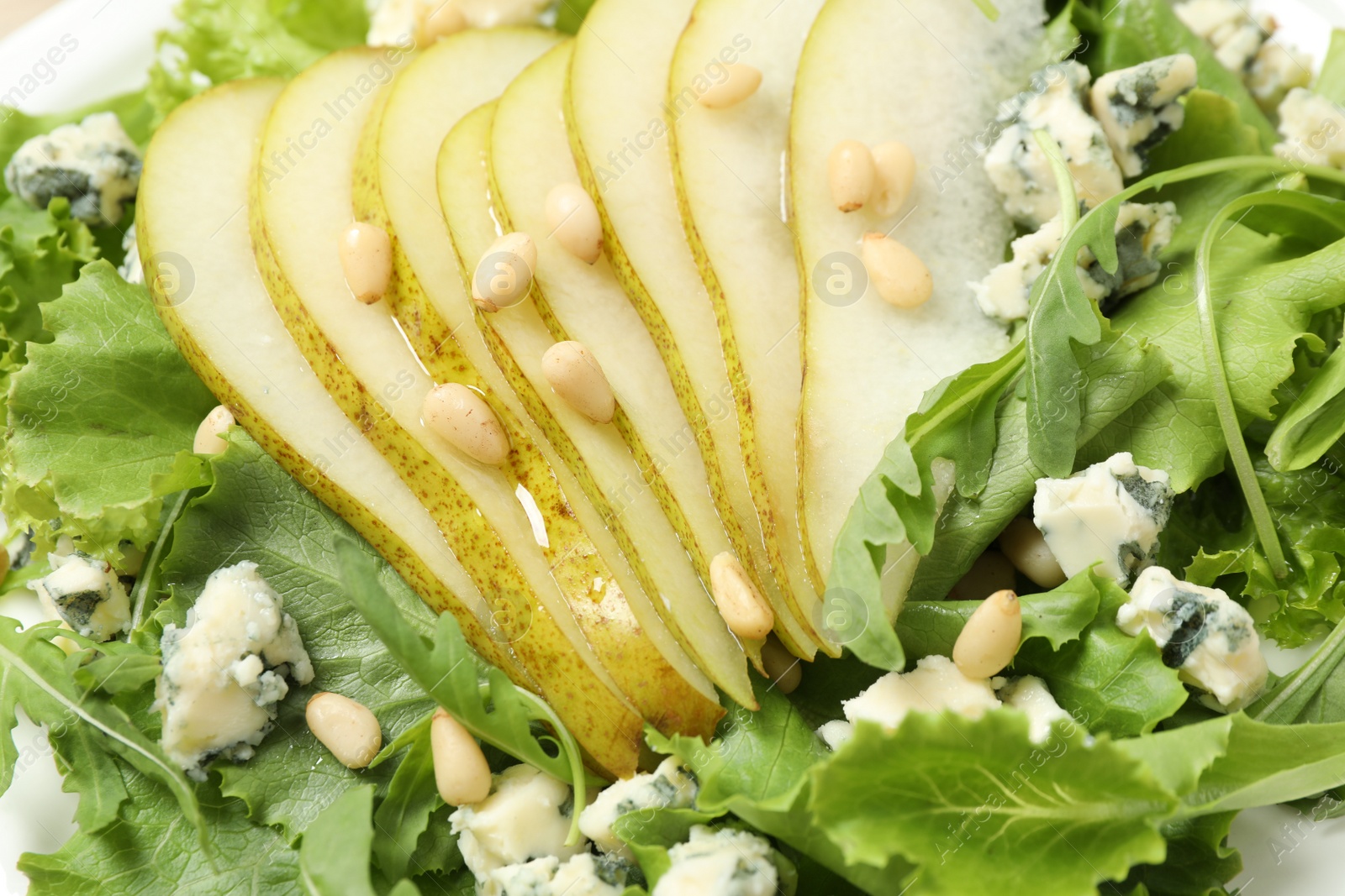 Photo of Delicious fresh salad with pear slices as background, closeup view