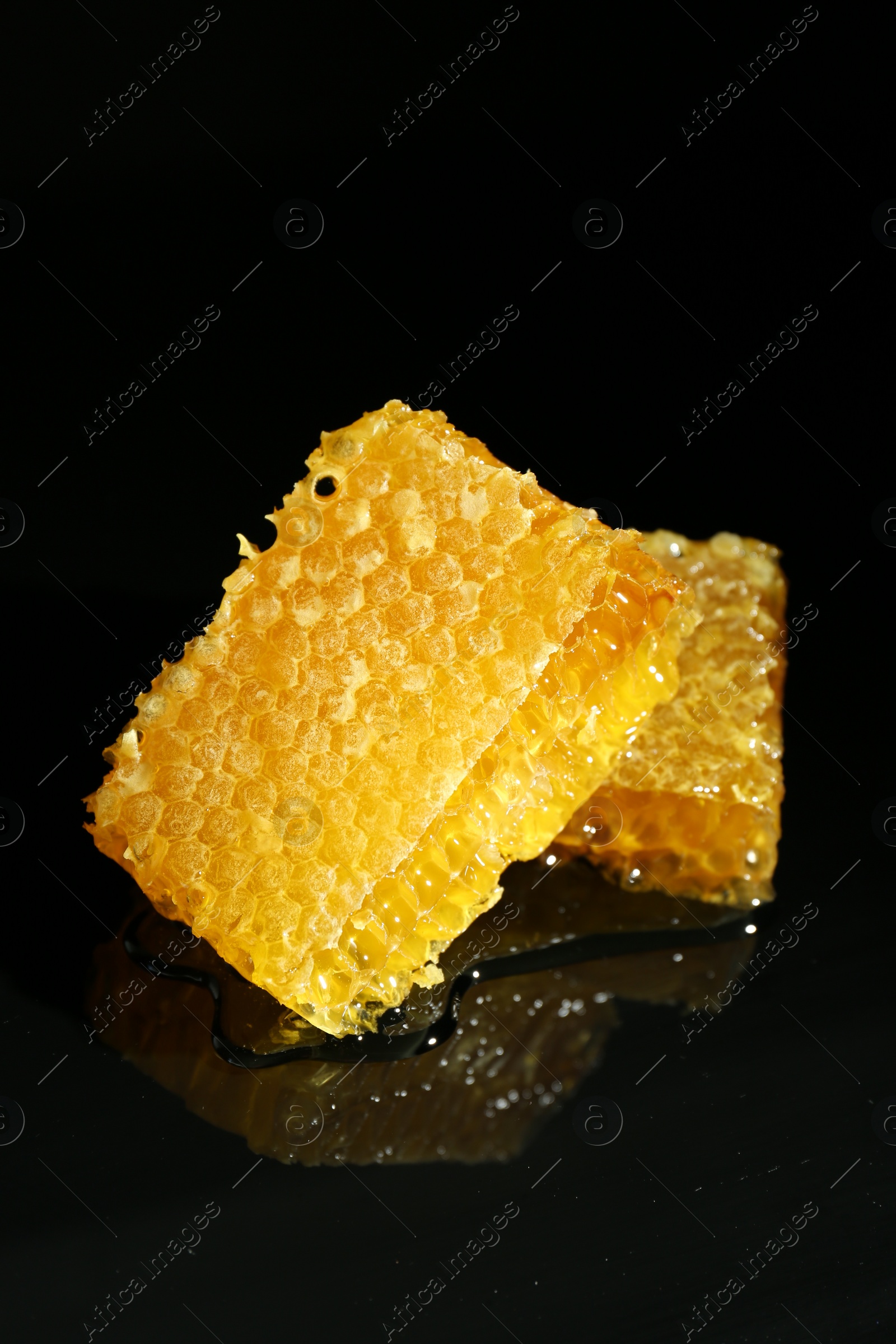 Photo of Natural honeycombs with tasty honey on black background