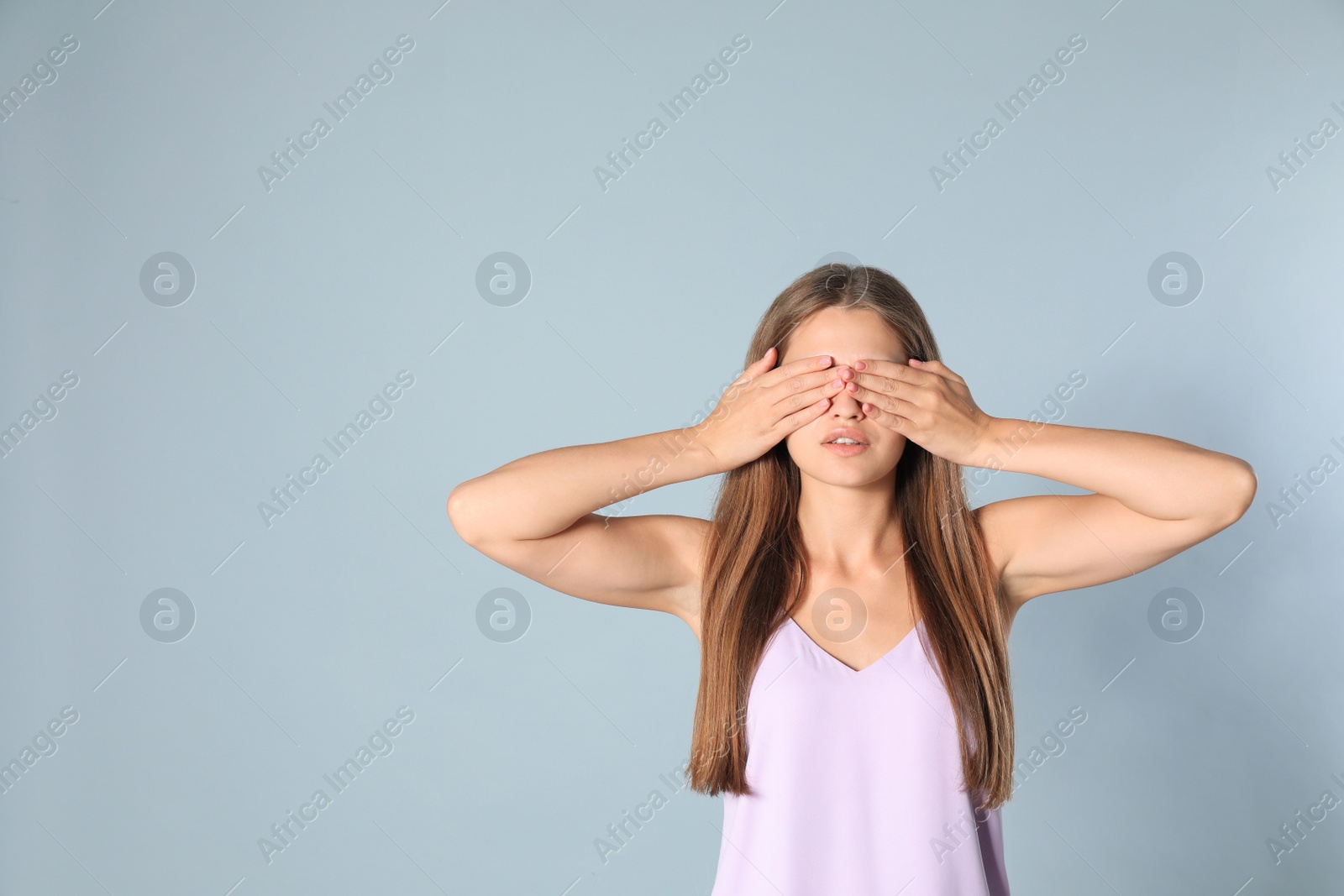 Photo of Young woman being blinded on grey background, space for text