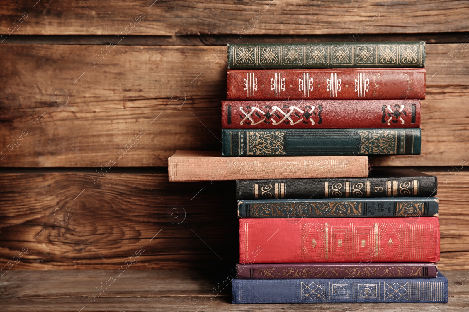 Photo of Collection of different books on table against wooden background