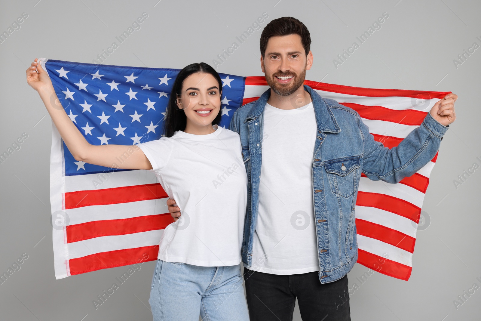 Photo of 4th of July - Independence Day of USA. Happy couple with American flag on grey background