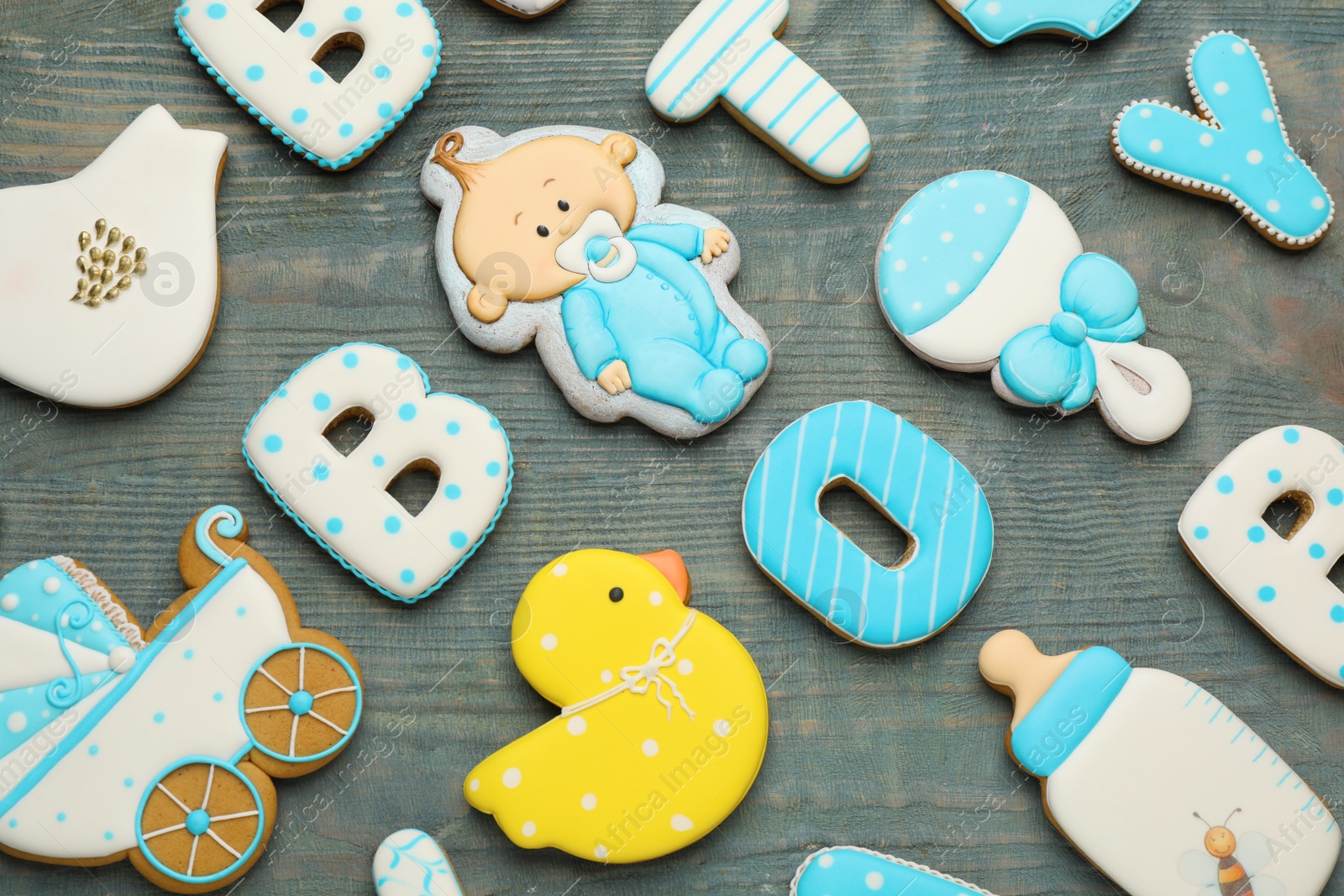 Photo of Set of baby shower cookies on light blue wooden table, flat lay