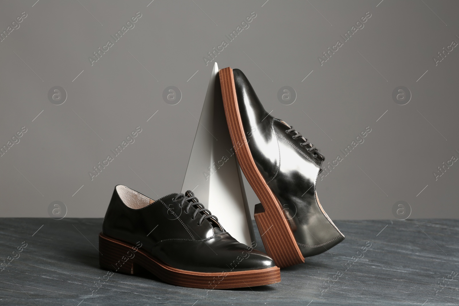 Photo of Composition with elegant shoes on table against grey background