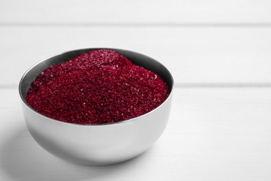 Photo of Bowl with dark red food coloring on white table, closeup. Space for text