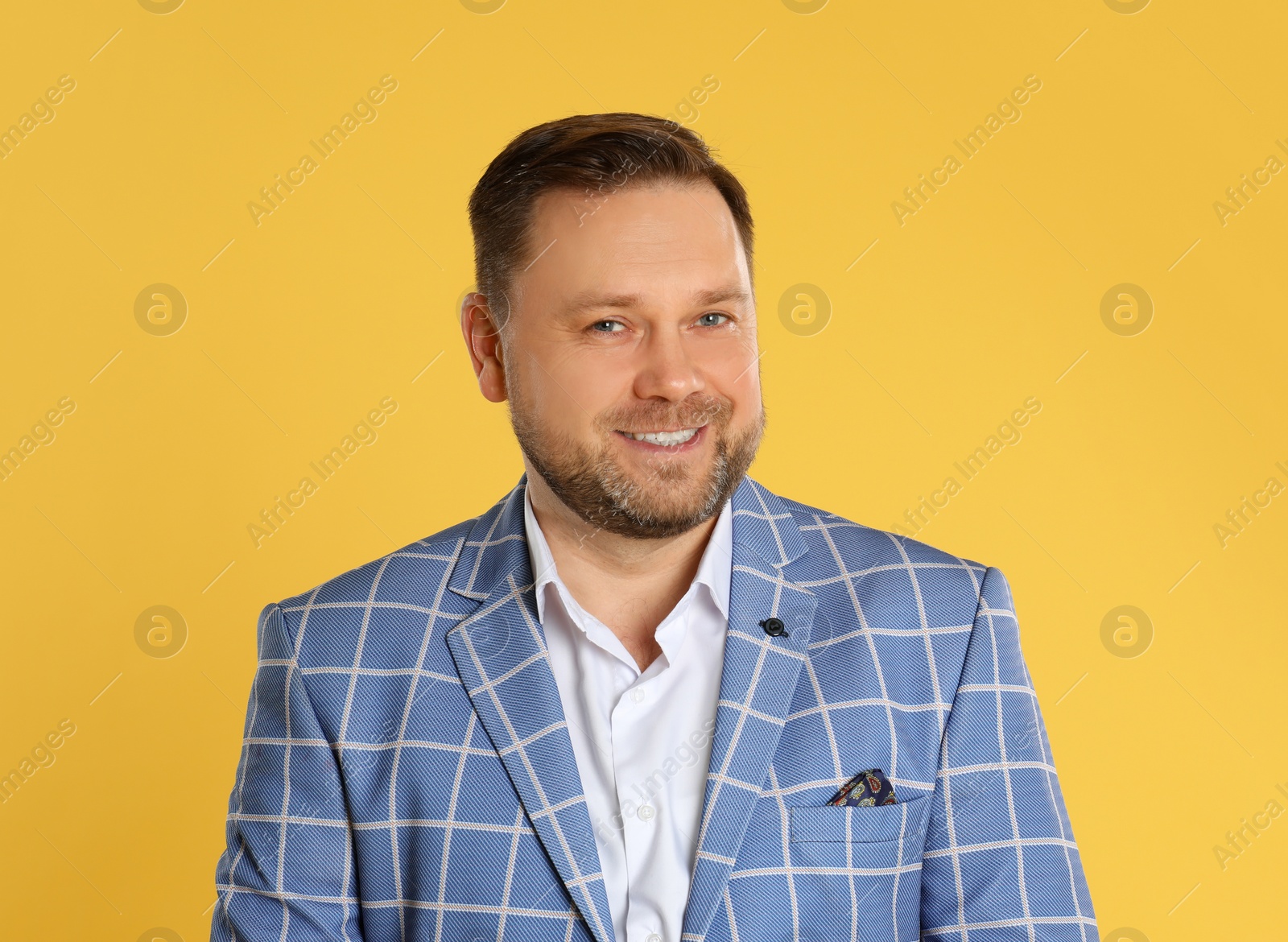 Photo of Portrait of happy mature man on yellow background