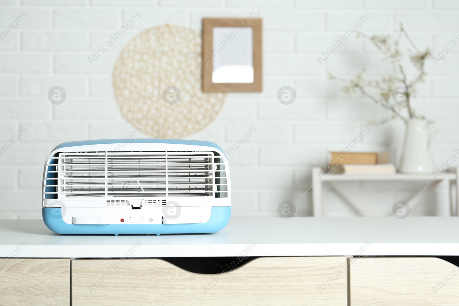 Photo of Modern air purifier on white table in room