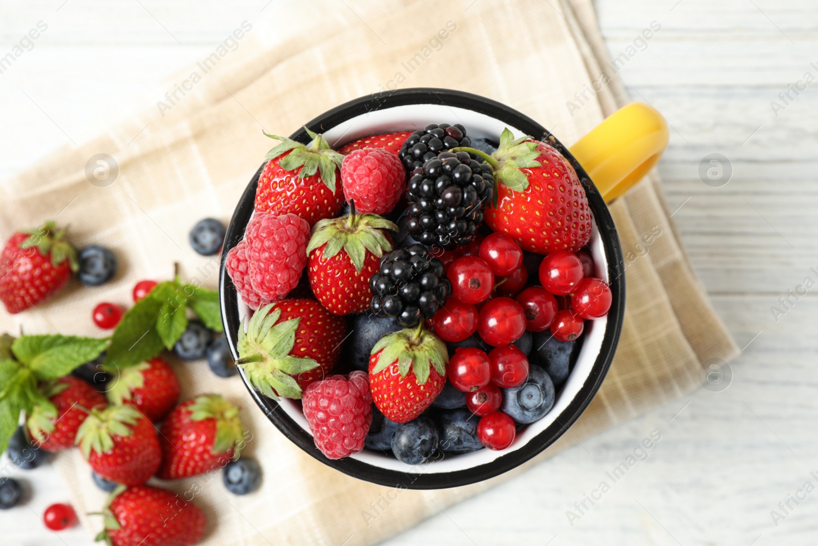 Photo of Mix of ripe berries on white wooden table, flat lay