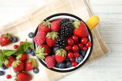 Photo of Mix of ripe berries on white wooden table, flat lay