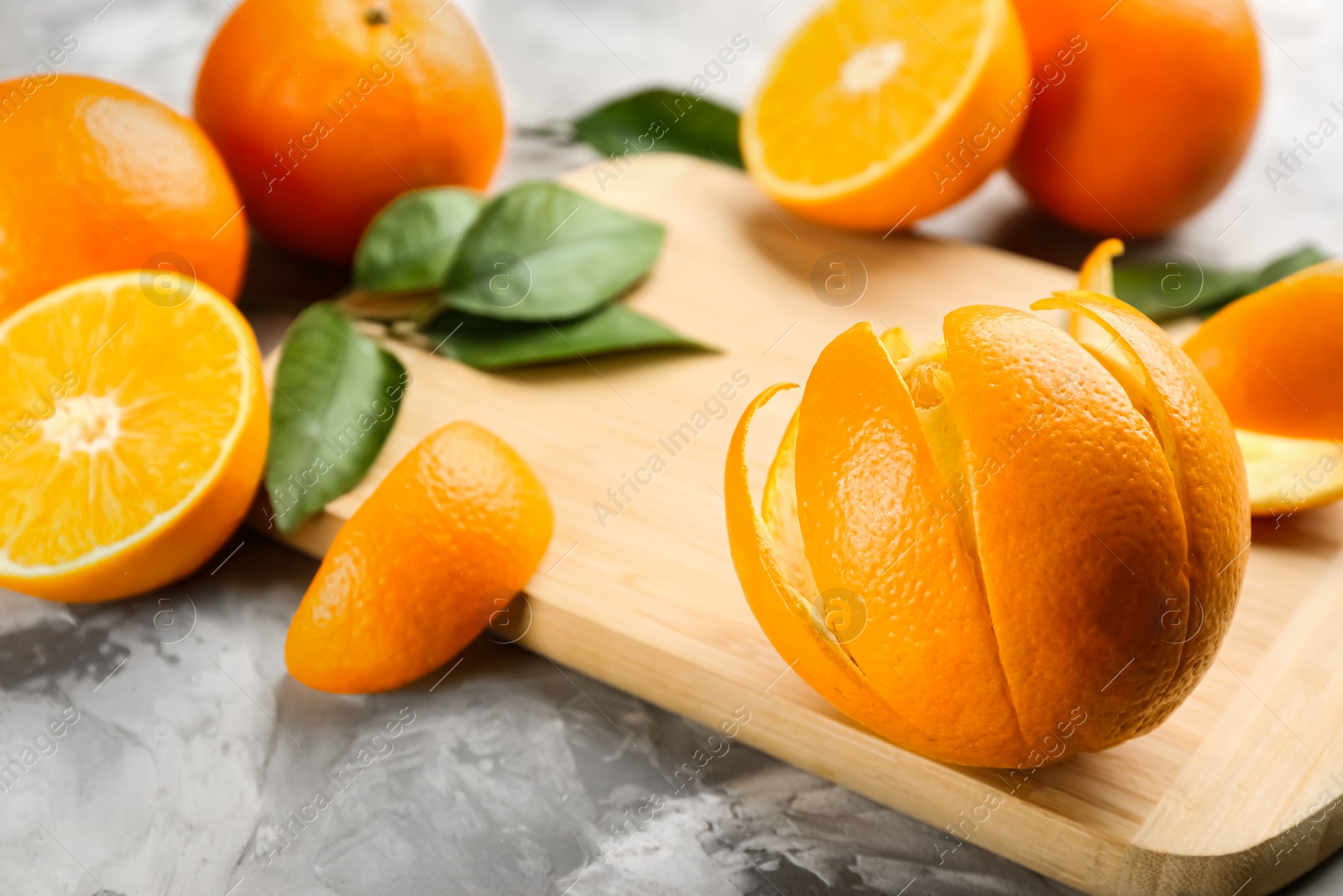 Photo of Orange fruit with peel on light grey table, closeup