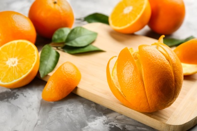 Photo of Orange fruit with peel on light grey table, closeup