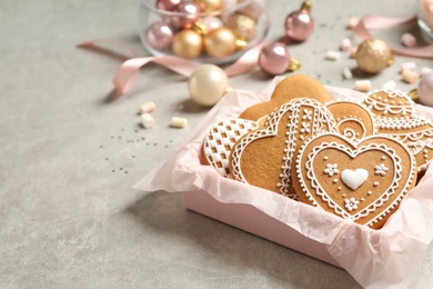 Photo of Tasty heart shaped gingerbread cookies and festive decor on light table. Space for text