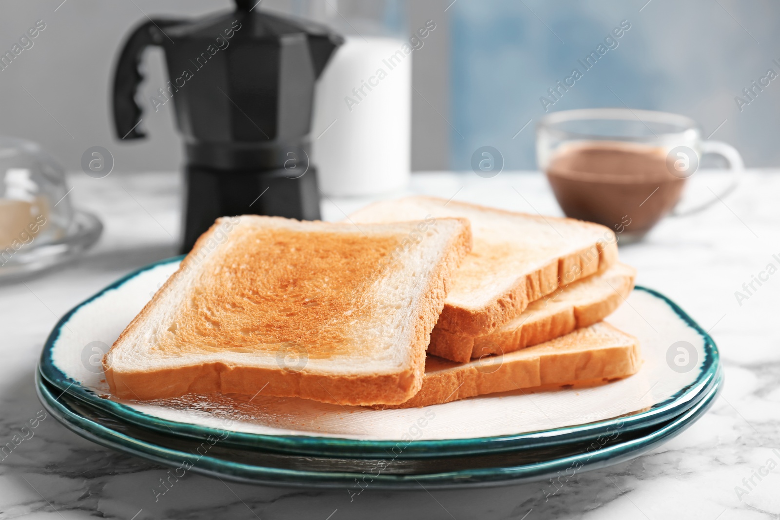 Photo of Plate with toasted bread on table