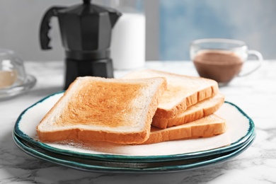 Plate with toasted bread on table