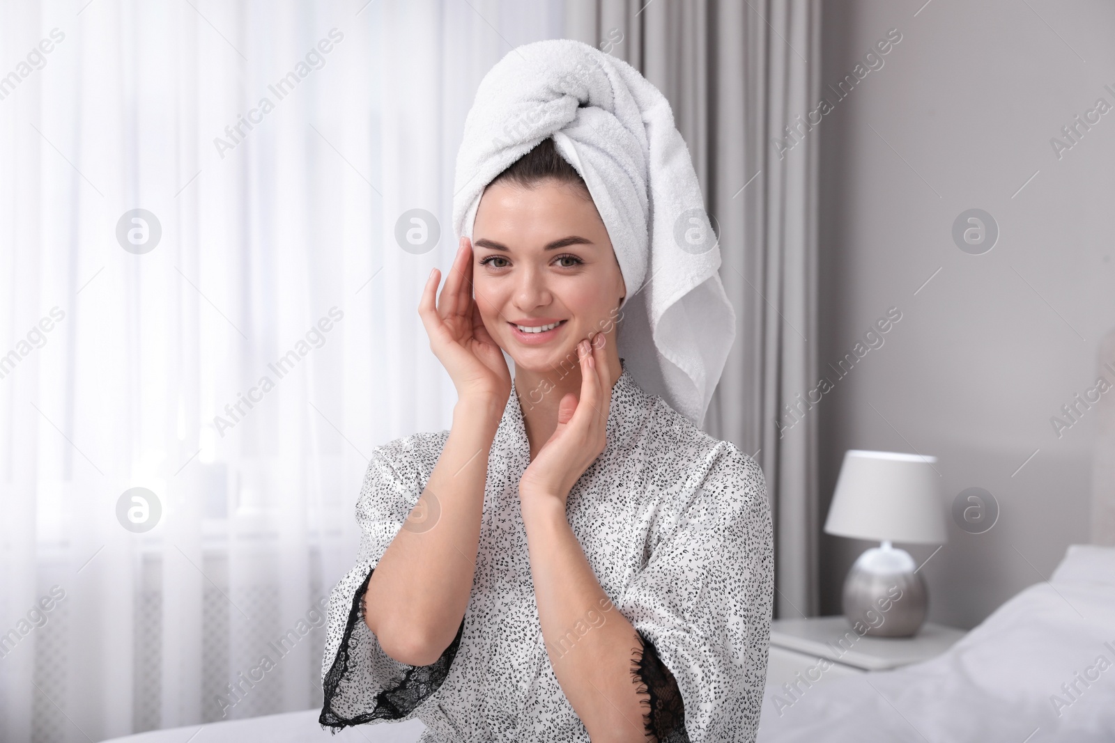 Photo of Beautiful young woman with hair wrapped in towel at home