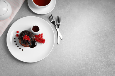 Photo of Delicious warm chocolate lava cake on grey table, flat lay. Space for text