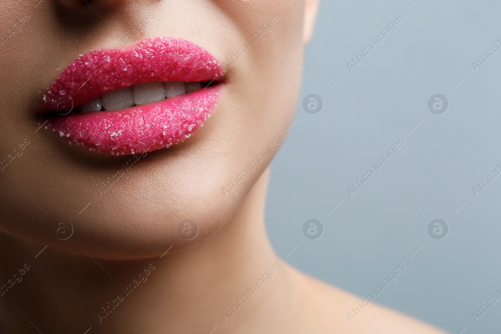 Photo of Closeup view of woman with lips covered in sugar on light grey background. Space for text