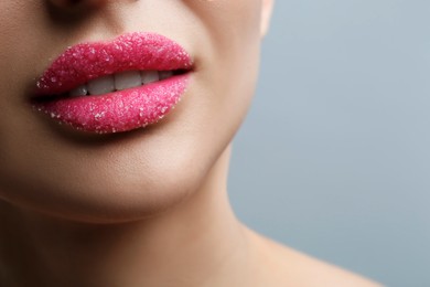 Closeup view of woman with lips covered in sugar on light grey background. Space for text