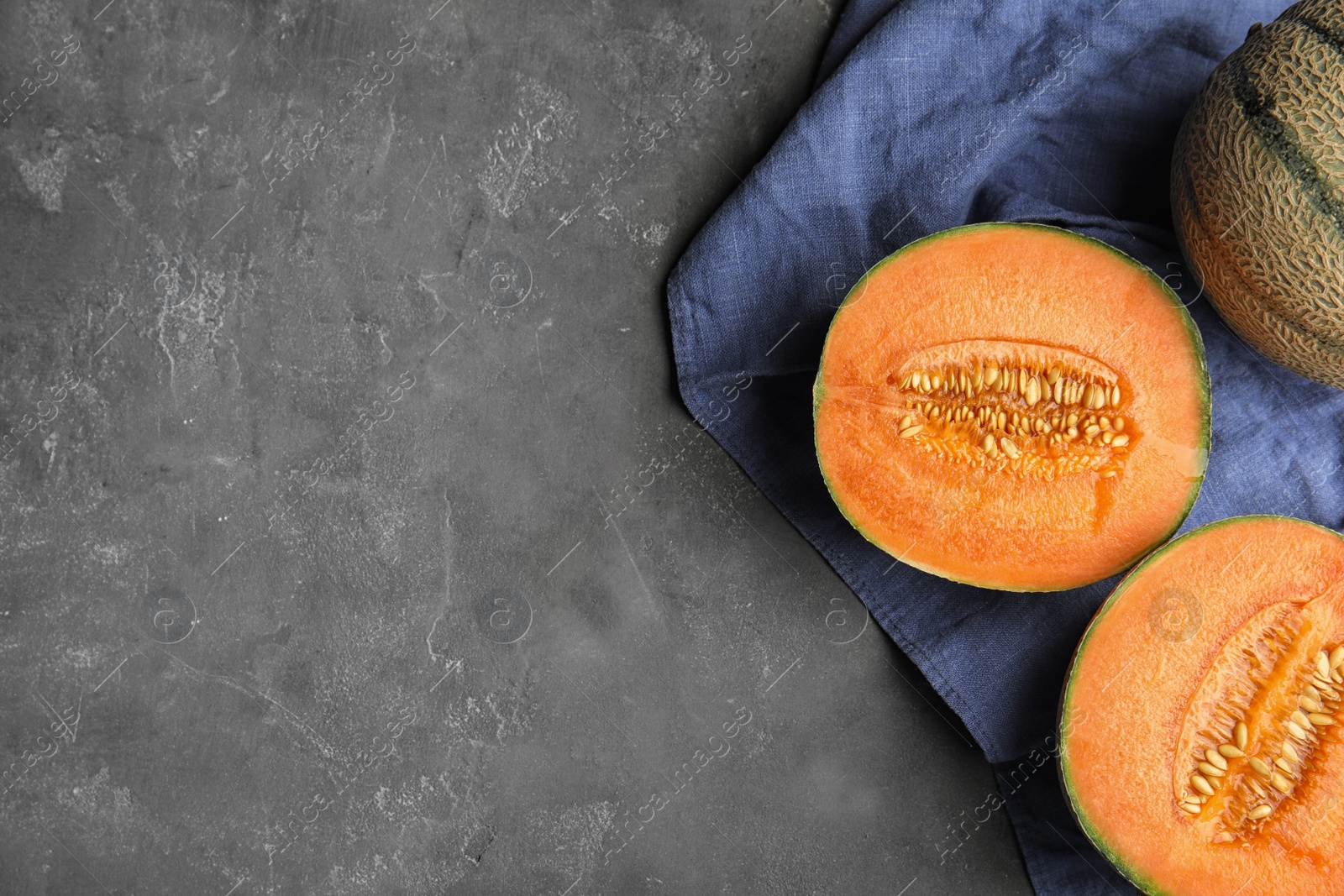 Photo of Tasty ripe cantaloupe melons on grey table, flat lay. Space for text