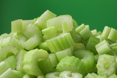 Photo of Fresh ripe cut celery on green background, closeup