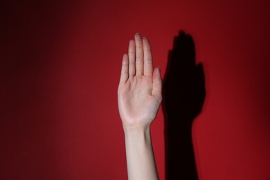 Photo of Woman showing open palm on red background, closeup