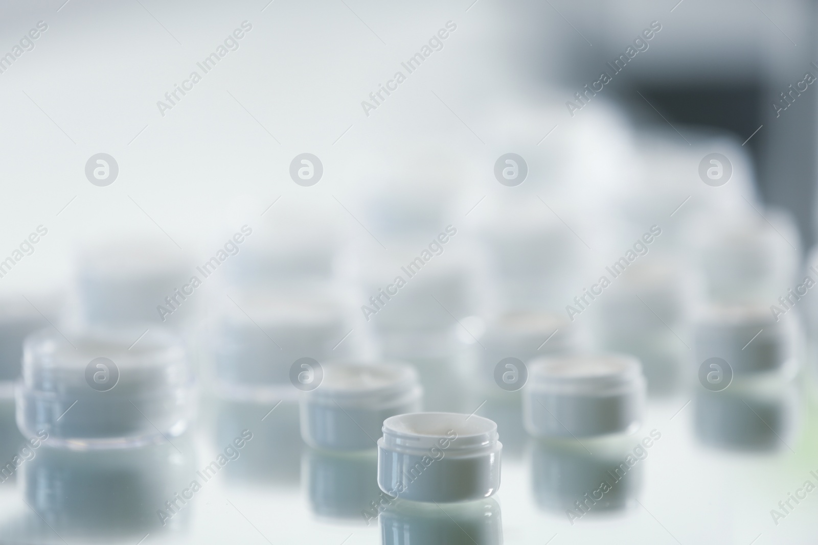 Photo of Jars with different cosmetic products in laboratory, closeup