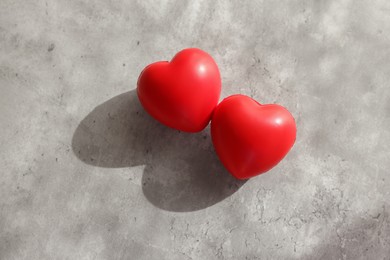 Two decorative hearts on gray textured table, above view