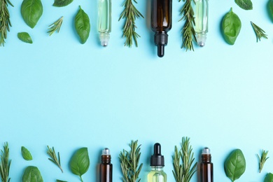 Flat lay composition with herbal essential oils and space for text on light blue background