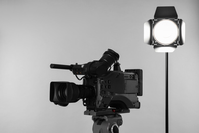 Photo of Professional video camera and lighting equipment on white background