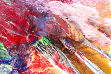 Photo of Abstract colorful artwork and brushes, closeup view