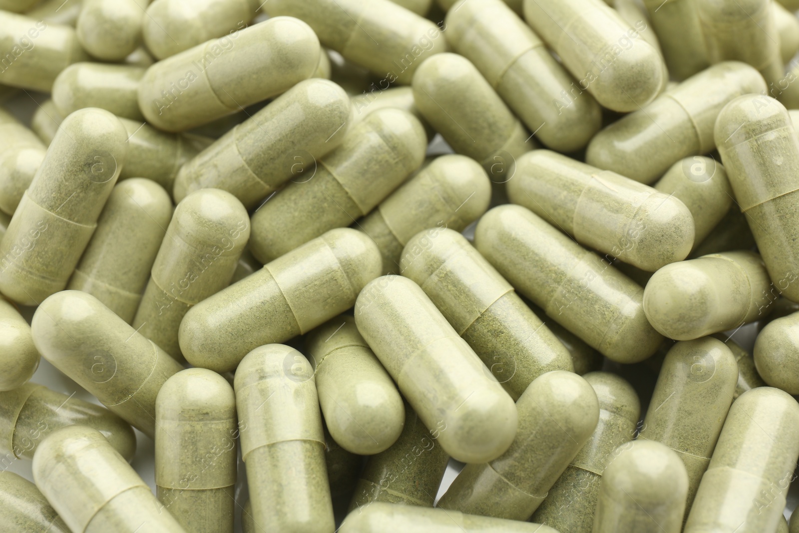 Photo of Light green vitamin capsules as background, top view