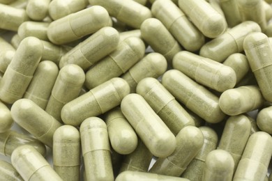 Photo of Light green vitamin capsules as background, top view