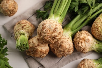 Photo of Fresh raw celery roots on white wooden table, above view
