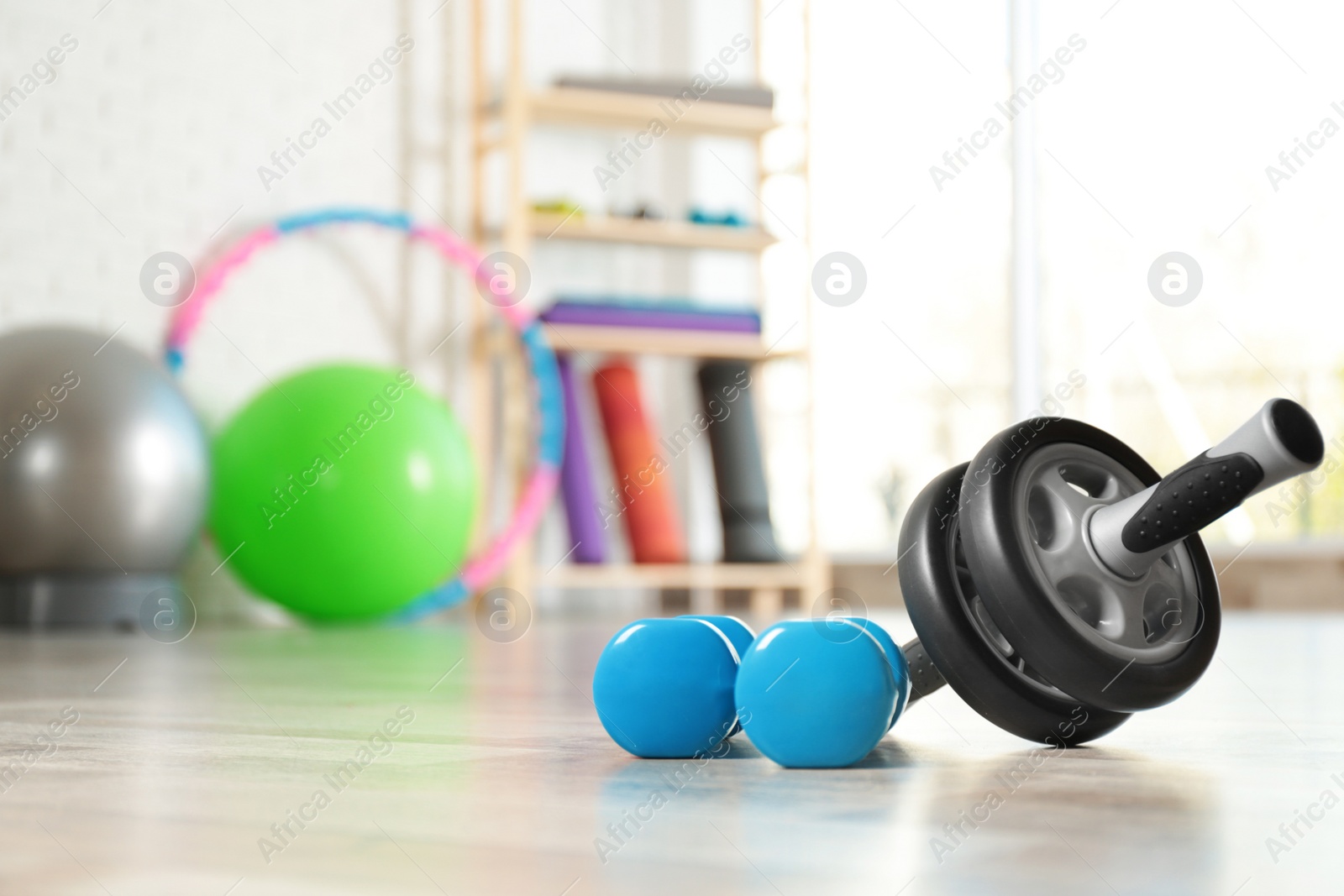 Photo of Fitness inventory on floor in spacious gym, space for text. Rehabilitation medicine