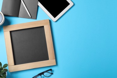 Photo of Flat lay composition with small chalkboard on light blue background, space for text