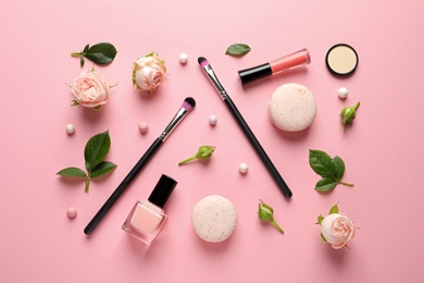 Flat lay composition with products for decorative makeup on pastel pink background