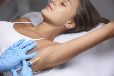 Photo of Young woman getting armpits injection in salon