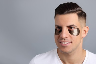 Photo of Man with dark under eye patches on grey background. Space for text