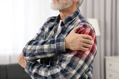 Image of Senior man suffering from pain in shoulder indoors, closeup