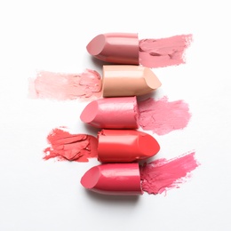 Photo of Different lipstick swatches on white background, top view