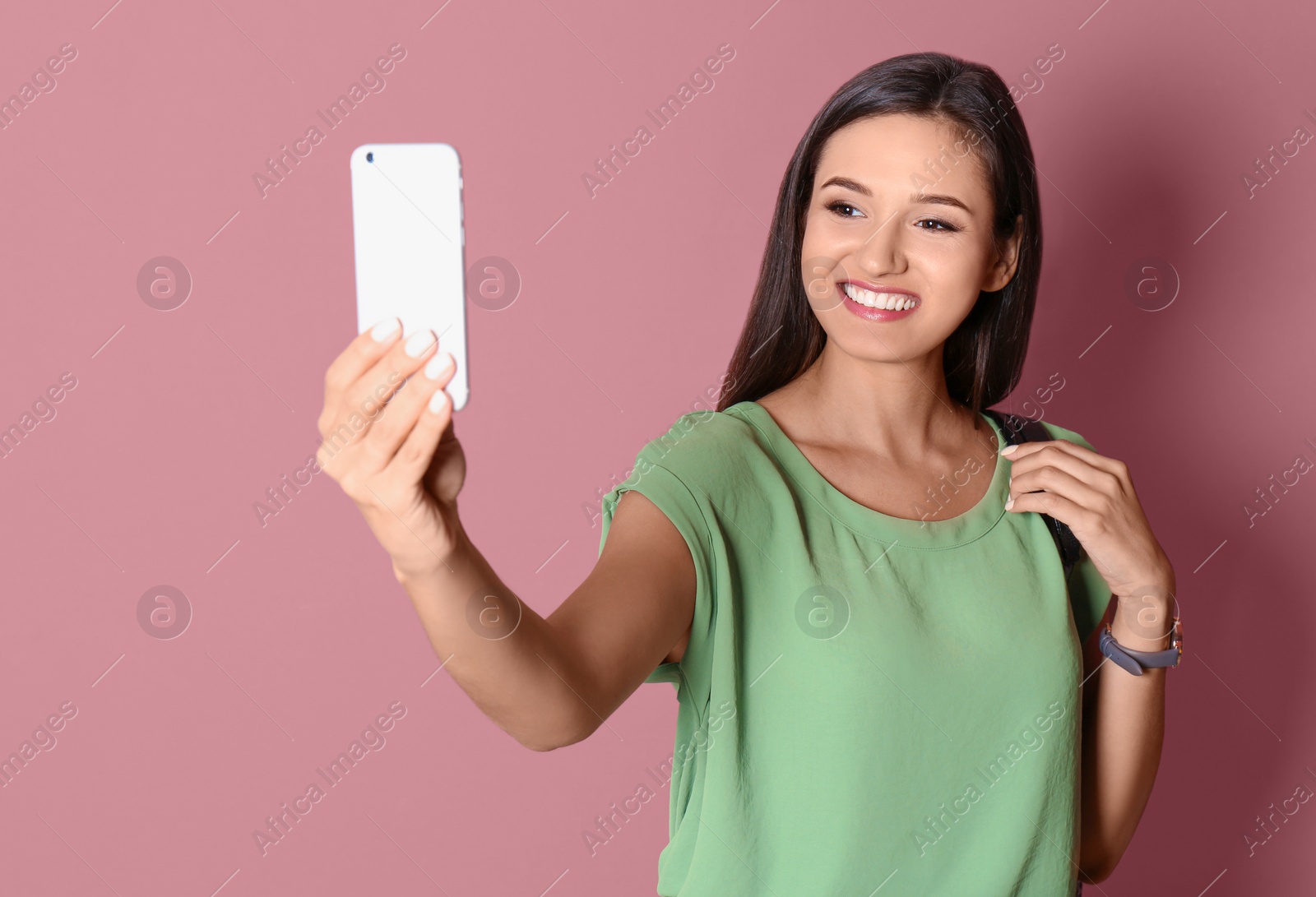 Photo of Young beautiful woman taking selfie against color background